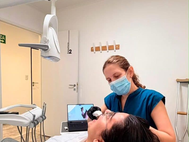 Odontóloga realizando un escaneo intraoral a una paciente.